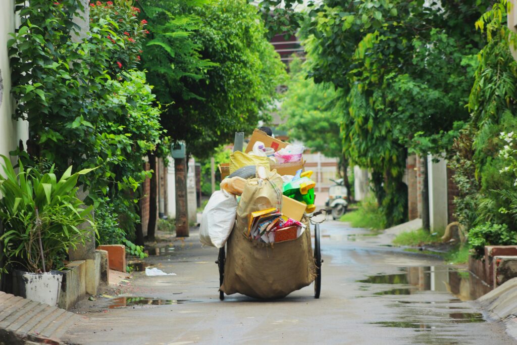 A street cart full of recyclable items on a lush, green street in Ludhiana, India.